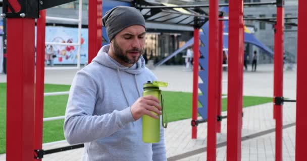 Attraktiver Sportler, der nach dem Training Wasser trinkt und den Körper mit Feuchtigkeit versorgt. — Stockvideo