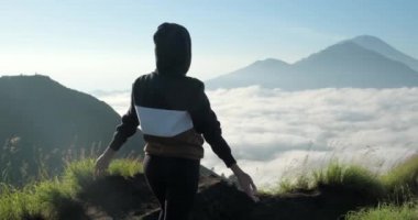 Genç bir gezgin kız İsviçre 'de dağın tepesinde oturuyor ve eğleniyor.