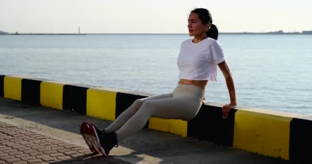 Atletyczna dziewczyna robi pompki na ulicy z krawężnika, trening na molo — Wideo stockowe