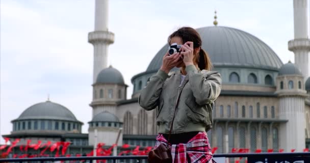 Meisje neemt een foto op de telefoon tegen de achtergrond van een moskee in de herfst dag — Stockvideo