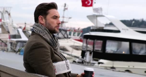 Glücklicher Geschäftsmann liest Zeitung, während er auf der Bank sitzt und türkische Nachrichten liest — Stockvideo