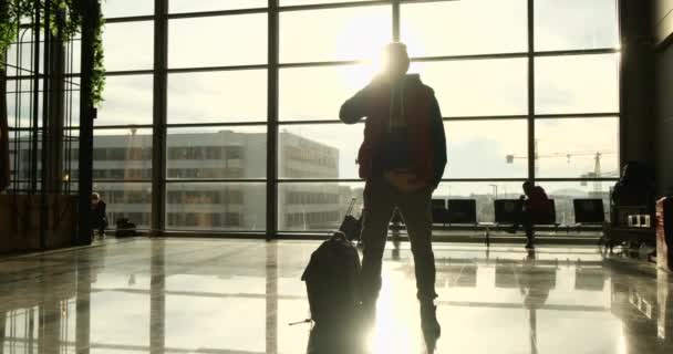 男は空港から飛行機を見ています。ターミナルの観光客スタンド — ストック動画