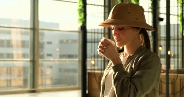 Catching up with the world.tourist in a discovery hat at the airport drink cofee — Stock Video