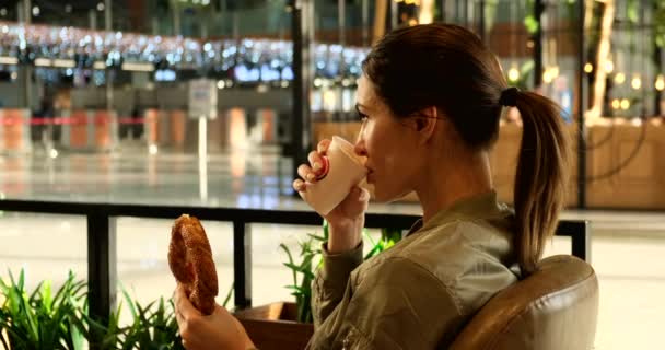 Kvinna på flygplatsen äter turkiskt simit och dricka kaffe, Istanbul Airport — Stockvideo