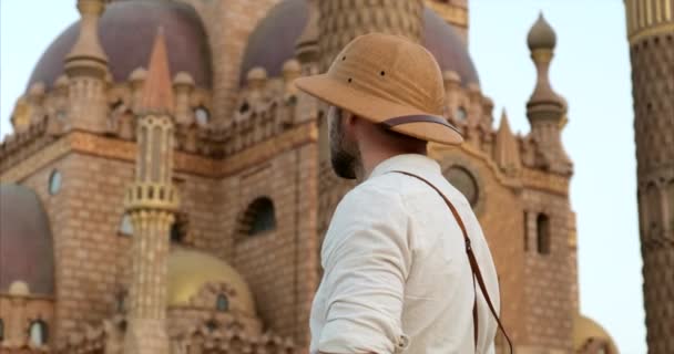 Турист стоїть з камерою біля мечеті, мінарет.археологія — стокове відео