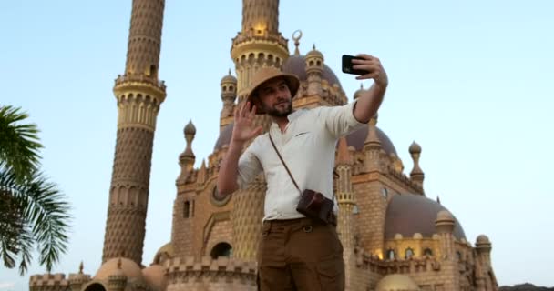 Mannen tar en selfie på telefonen i gamla stan marknaden i Kairo moskén. — Stockvideo