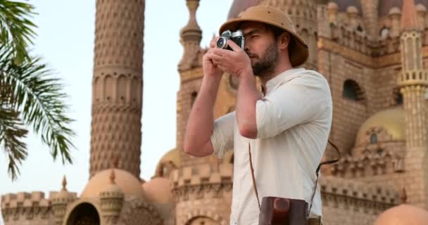 Un turista se para con una cámara cerca de la mezquita, minaret.archeology — Vídeos de Stock