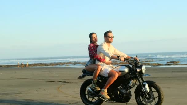 Okyanus kıyısındaki plajda motosiklet sürerken aşık mutlu çift. — Stok video