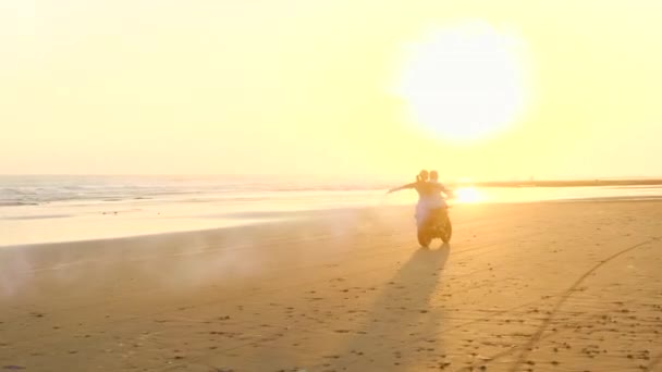 Mooi paar op een retro brommer genieten van het leven op het strand met gekleurde bommen — Stockvideo