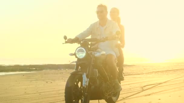 Όμορφη αγάπη ζευγάρι βόλτες με ταχύτητα σε μια μοτοσικλέτα στην άμμο, Ocean Beach — Αρχείο Βίντεο