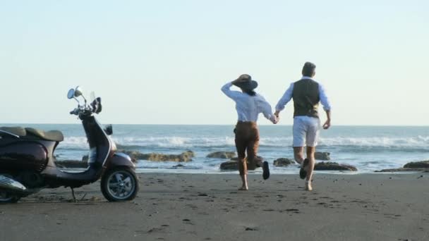 Feliz pareja corriendo en la playa — Vídeo de stock