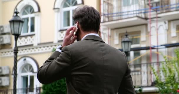 Atractivo joven empresario en traje elegante en el distrito de negocios — Vídeos de Stock