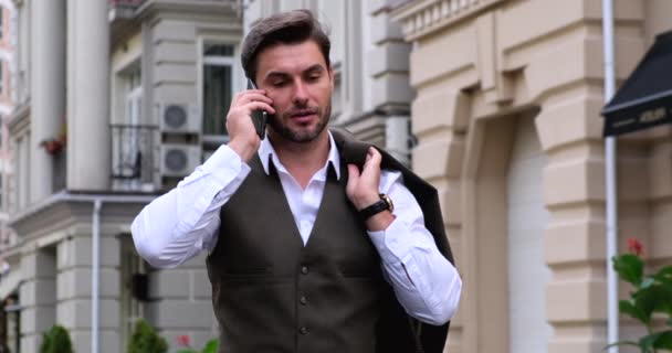 Bel homme d'affaires parlant sur un téléphone portable tout en travaillant dans la rue — Video