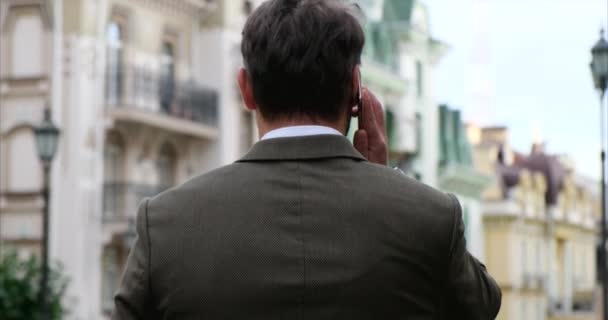 Привлекательный молодой бизнесмен в стильном костюме в деловом районе — стоковое видео