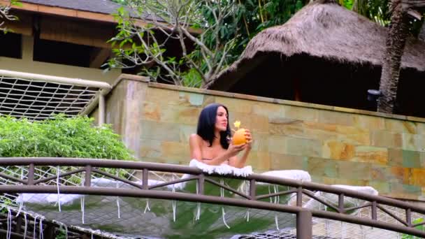 Estate ragazza in costume da bagno con bevanda al cocco a natura tropicale — Video Stock