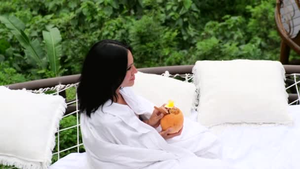 Літня дівчина в купальнику з кокосовим напоєм на тропічній природі — стокове відео