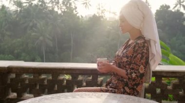 Kahveli güzel bir kadın balkondan manzaranın tadını çıkarıyor, Bali.