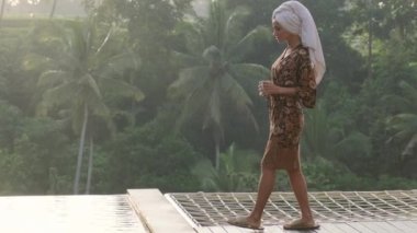 Havlu giysili güzel bir kadın dinleniyor dinleniyor dinleniyor dinlenme odasında bir sandalyede