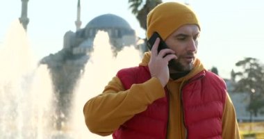 Bir adam cep telefonuyla konuşur.