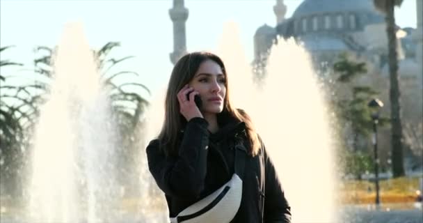 Μια γυναίκα μιλάει με κλήση σε ένα κινητό τηλέφωνο — Αρχείο Βίντεο