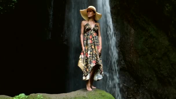 Mulher sexy ficar na rocha na bela cachoeira na selva ao lado do penhasco — Vídeo de Stock