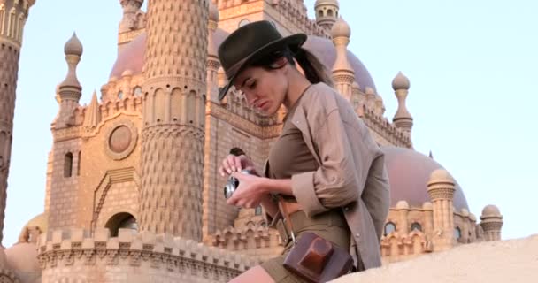 Турист стоит с фотоаппаратом рядом с мечетью, минаретом, археологией — стоковое видео