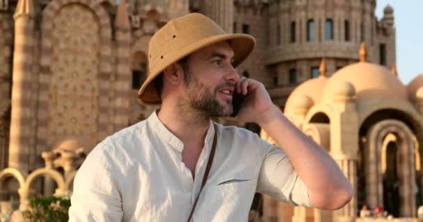 Τουρίστας μιλάει στο τηλέφωνο, ενώ κάθεται στο τζαμί γρασίδι, Ινδία — Αρχείο Βίντεο