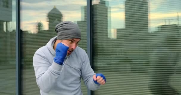 Kickbox Muscular Fighter avec bandages bleus sur le fond d'une fenêtre — Video