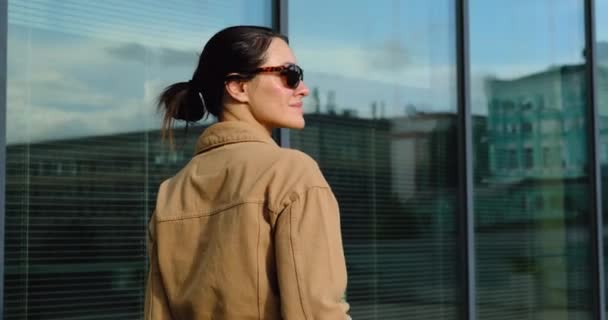 Mooie stijlvolle vrouw wandelen door het business center met koffie USA — Stockvideo