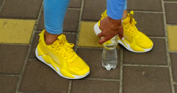近照跑鞋。女孩在街上穿运动鞋，瓶子 — 图库视频影像