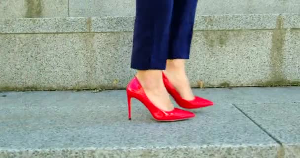 Όμορφα γυναικεία πόδια σε κόκκινα παπούτσια είναι τα πόδια γύρω από την πόλη. Επιχειρηματίας — Αρχείο Βίντεο