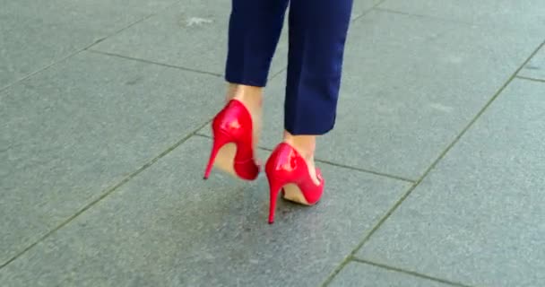 Pernas femininas bonitas em sapatos vermelhos estão andando ao redor da cidade. Empresária — Vídeo de Stock