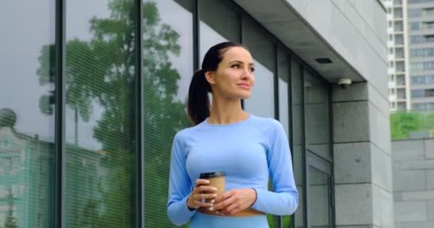 Happy Sport kobieta relaks po długiej podróży, picia kawy w pobliżu stadionu — Wideo stockowe