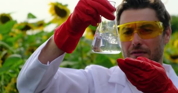 Asistente de laboratorio con guantes y bata blanca trabajando en el campo — Vídeos de Stock