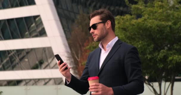 Businessman walking up the stairs with coffee and talking on the phone — Stock Video