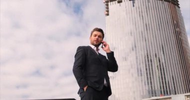 Cep telefonuyla konuşan yakışıklı bir iş adamı. İş görüşmesi konsepti
