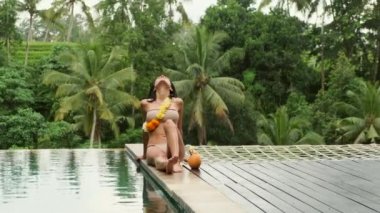  Hindistan cevizi Hawaii ile yaz tatilinde lüks bir villada dinlenen bir kadın.