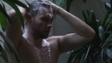Adam tropik şelalenin altında duş alıyor, Bali. Güzel, seksi adam.