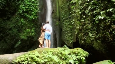 Siyah elbiseli genç kadın pirinç tarlalarında yürüyor Bali 