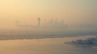 Aşağıdaki Palm Jumeirah adası ile sabah sisi içinde Dubai ufuk çizgisinin havadan görünüşü. Lüks yaşam tarzı, modern mimari, turizm, emlak yatırımı ve BAE 'de gelecekteki kentsel kalkınma