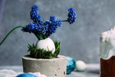 Mavi, koyu mavi paskalya yumurtaları gri masada.