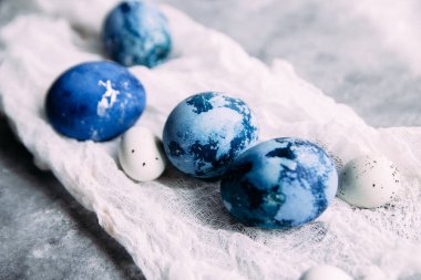 Mavi, koyu mavi paskalya yumurtaları gri masada.