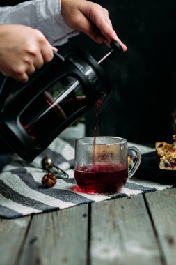 Siyah üzümlü kısa hamurlu pasta ve koyu arkaplanda çay.