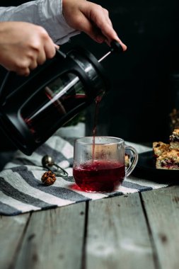 Siyah üzümlü kısa hamurlu pasta ve koyu arkaplanda çay.