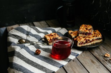 Siyah üzümlü kısa hamurlu pasta ve koyu arkaplanda çay.