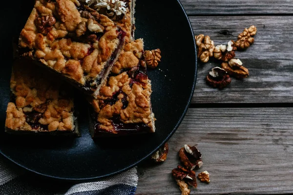 Siyah üzümlü kısa hamurlu pasta ve koyu arkaplanda çay.