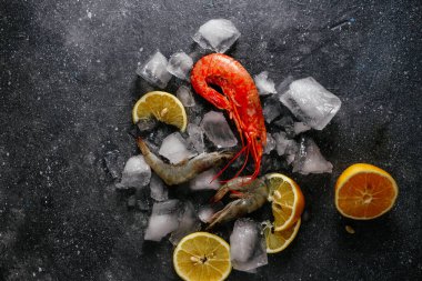 Buzlu karides, gri arka planda limon.