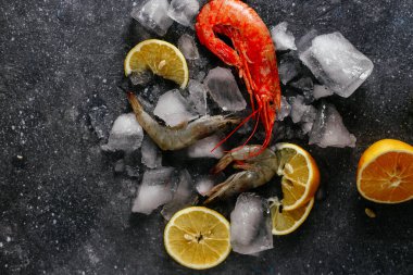 Buzlu karides, gri arka planda limon.