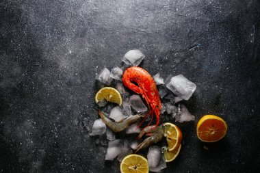 Buzlu karides, gri arka planda limon.
