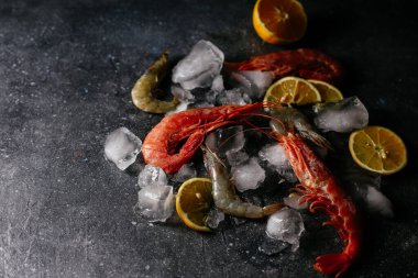 Buzlu karides, gri arka planda limon.